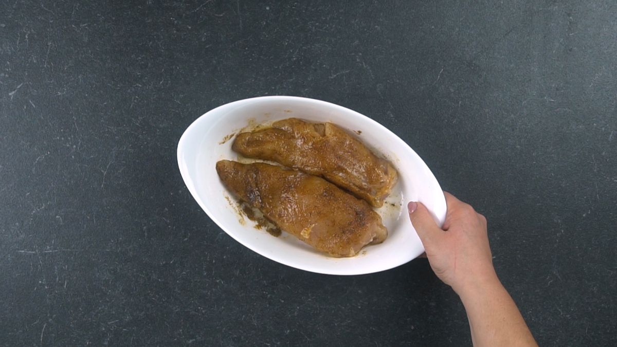 seasoned chicken breast in oval white baking dish