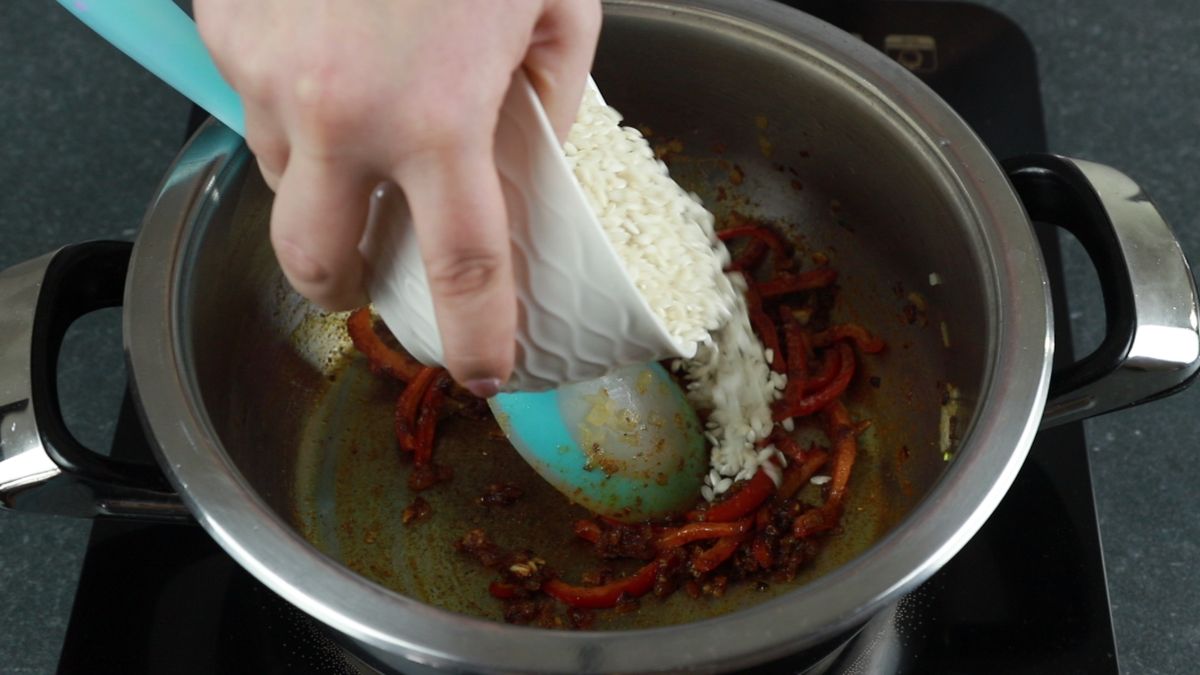 orzo being poured into saucepan