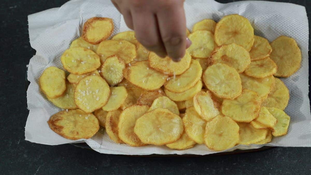 hand salting fried Italian seasoned fries