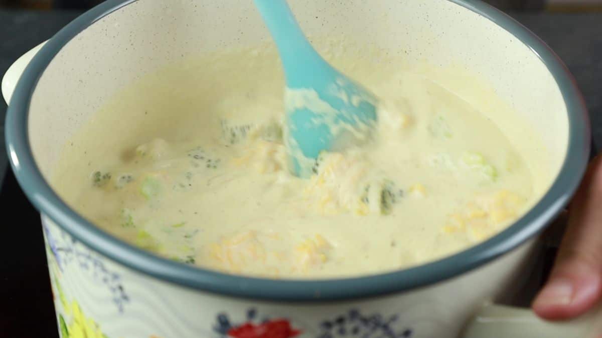 blue spoon stirring soup in soup pot