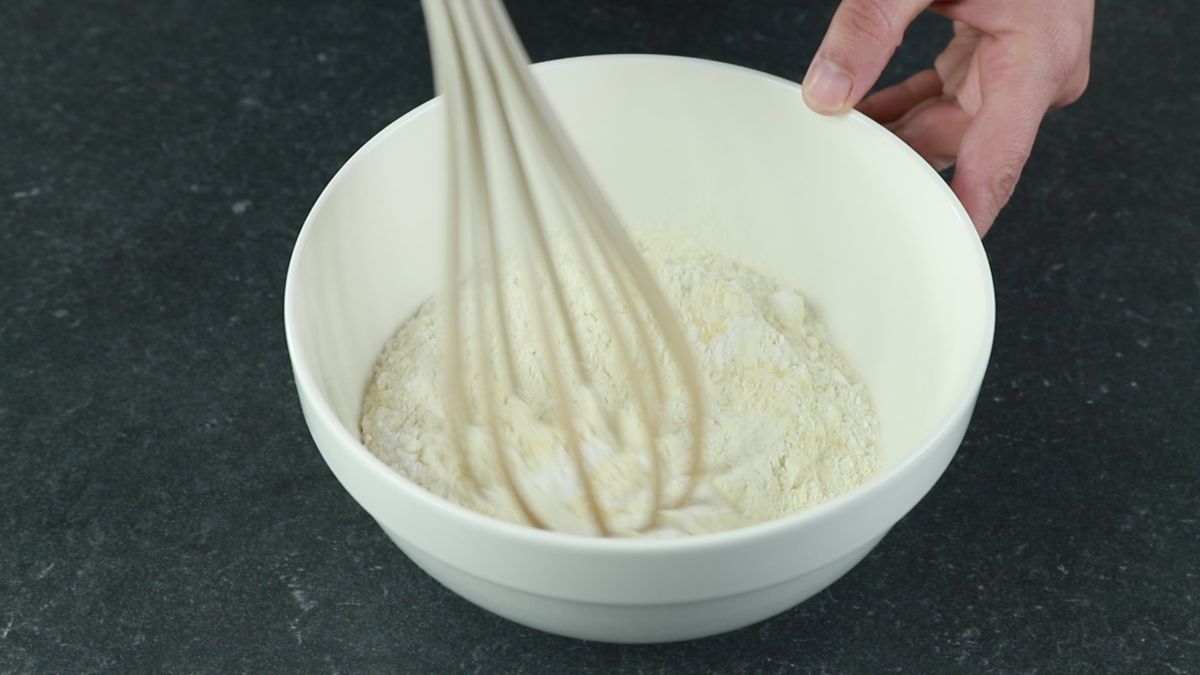 flour being whisked in white bowl