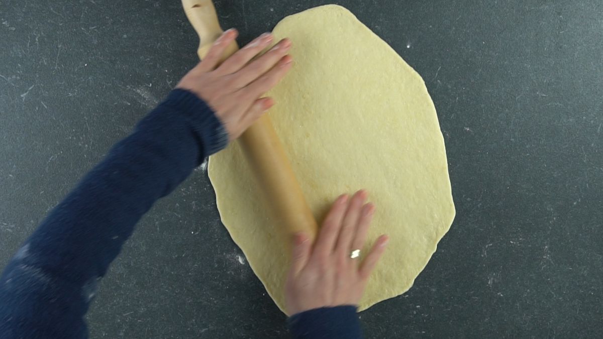 dough being rolled out on gray table