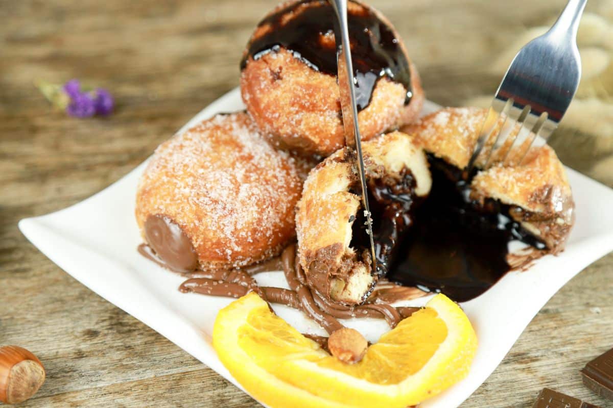 knife and fork cutting open nutella donut