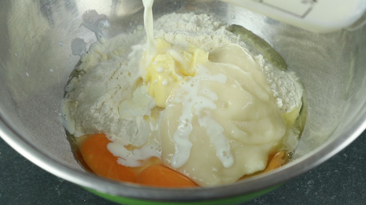 liquid being poured into bowl of flour