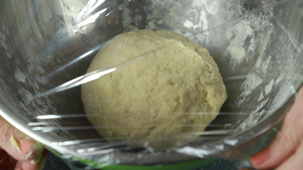 ball of dough covered with plastic wrap