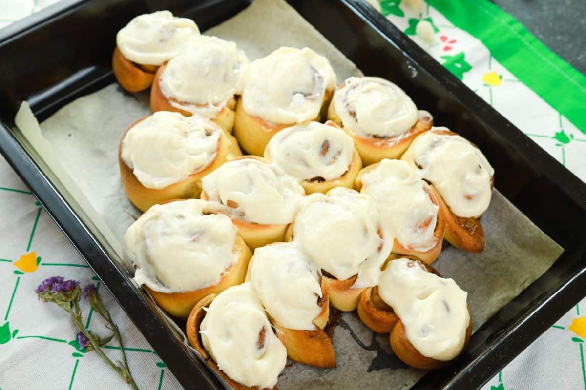 cream cheese icing on top of cinnamon rolls in shape of Christmas tree