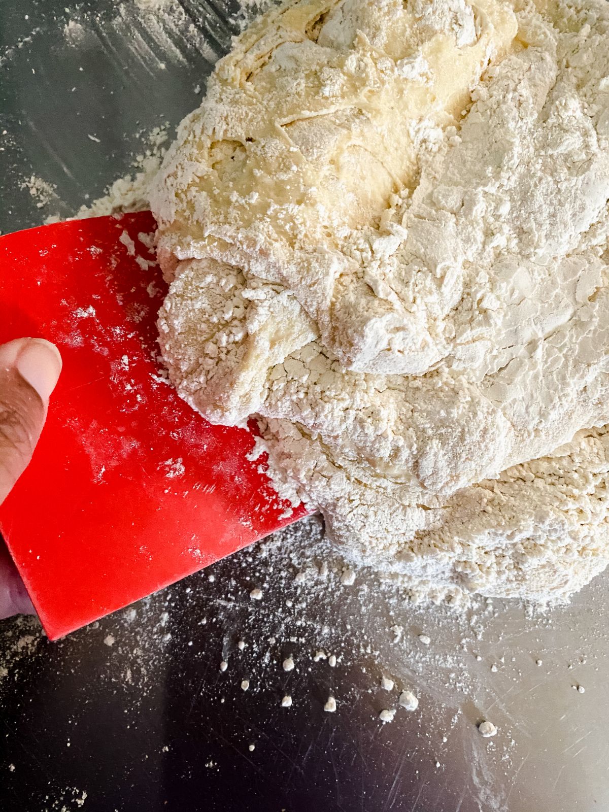 red table scraper lifting dough