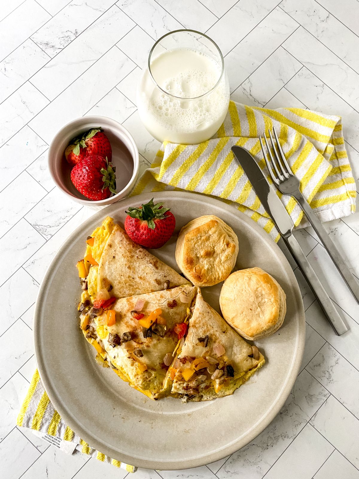 quesadilla on plate with biscuits and strawberries