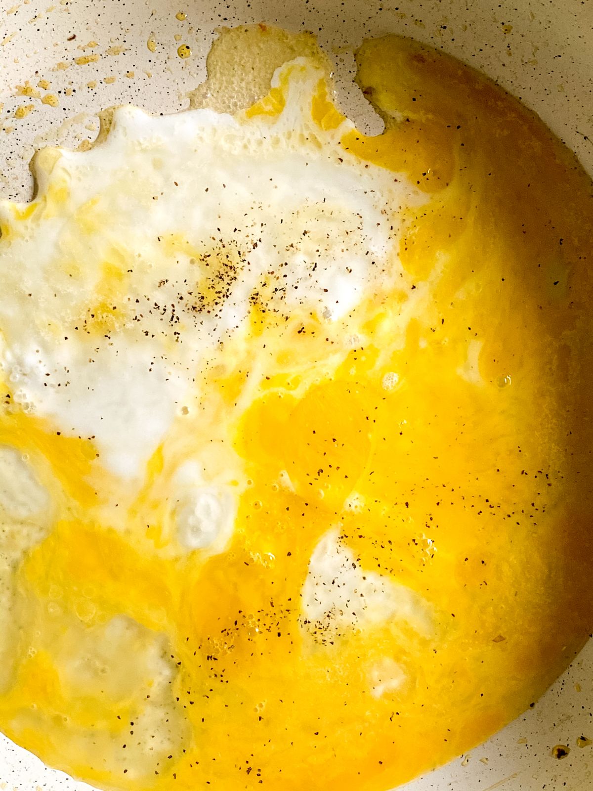 eggs being cooked in cream plate