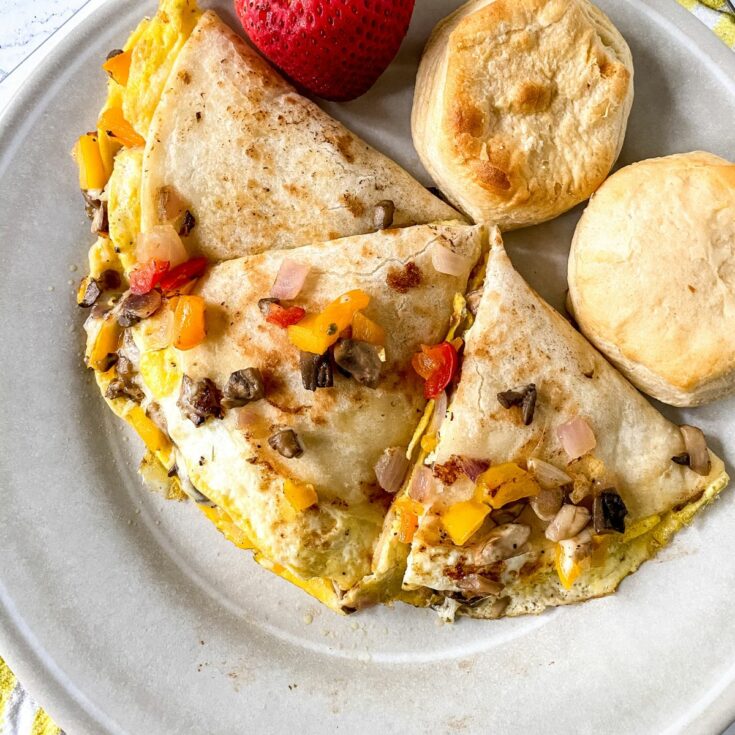 quesadilla on plate with biscuits and strawberries