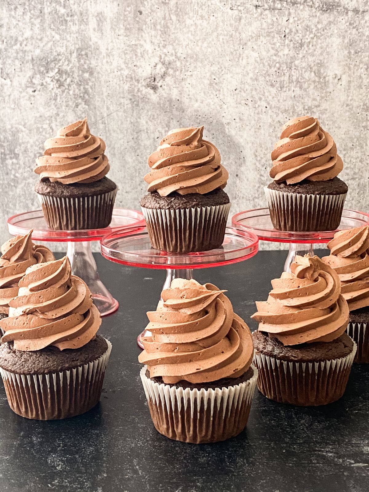 chocolate cupcakes with chocolate frosting on table