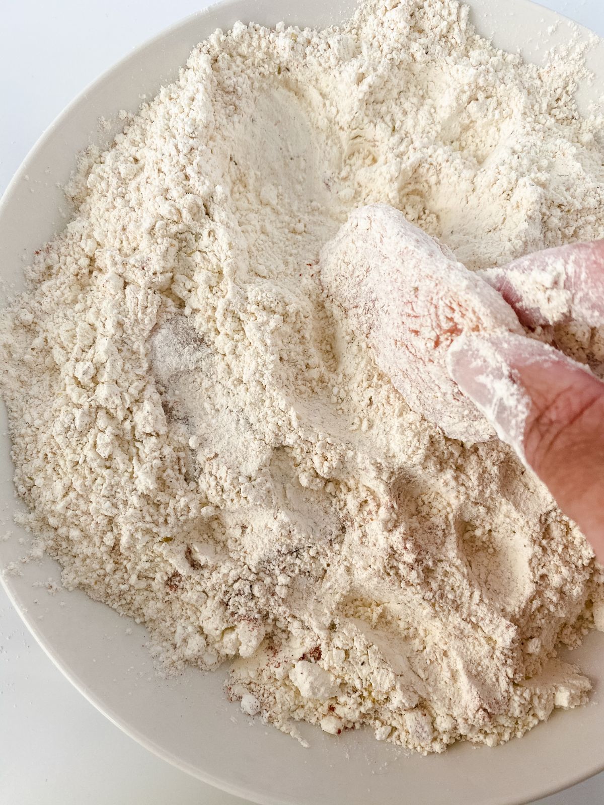 chicken being dipped into seasoned flour