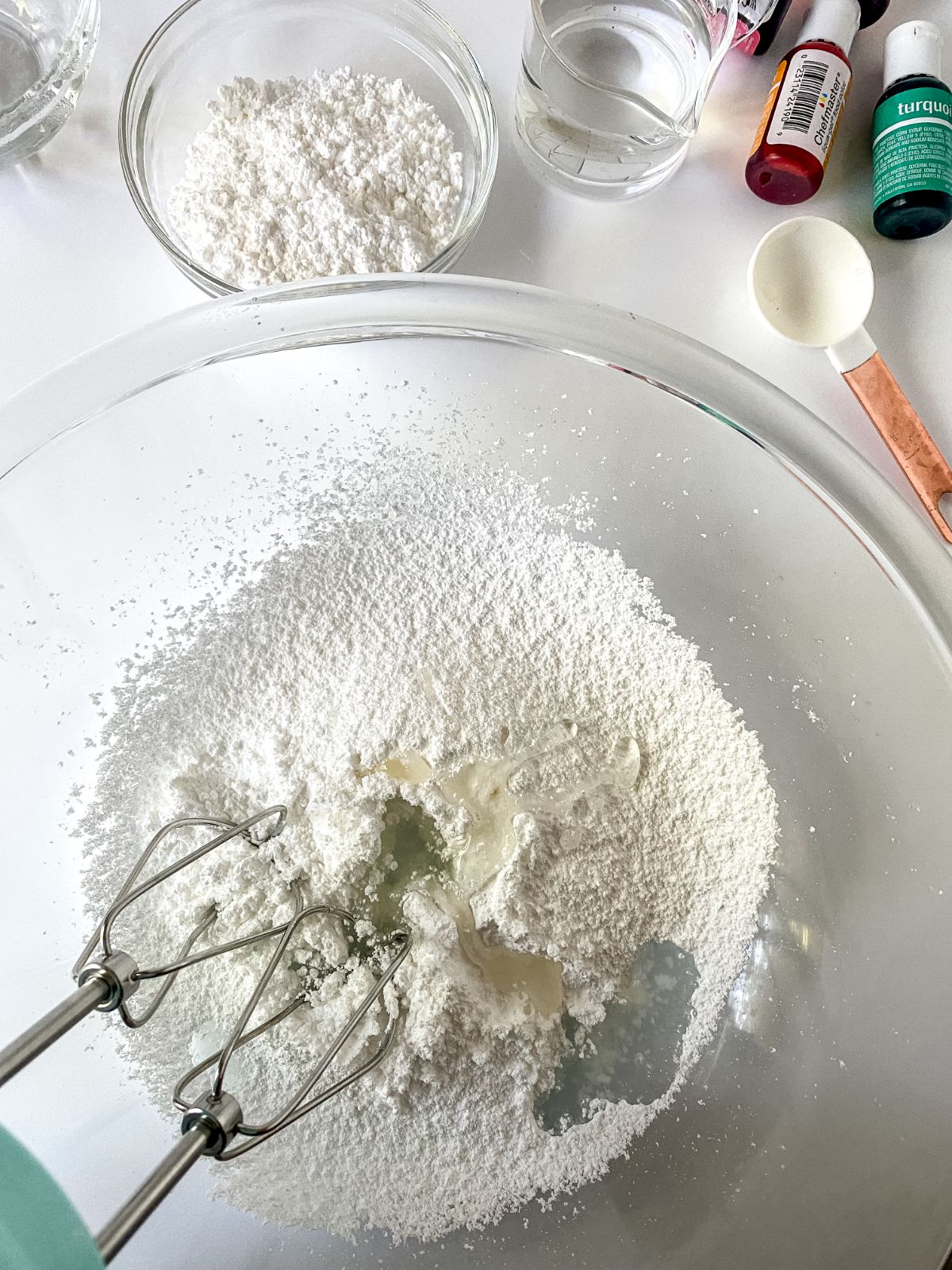 corn syrup being whisked into bowl of powdered sugar