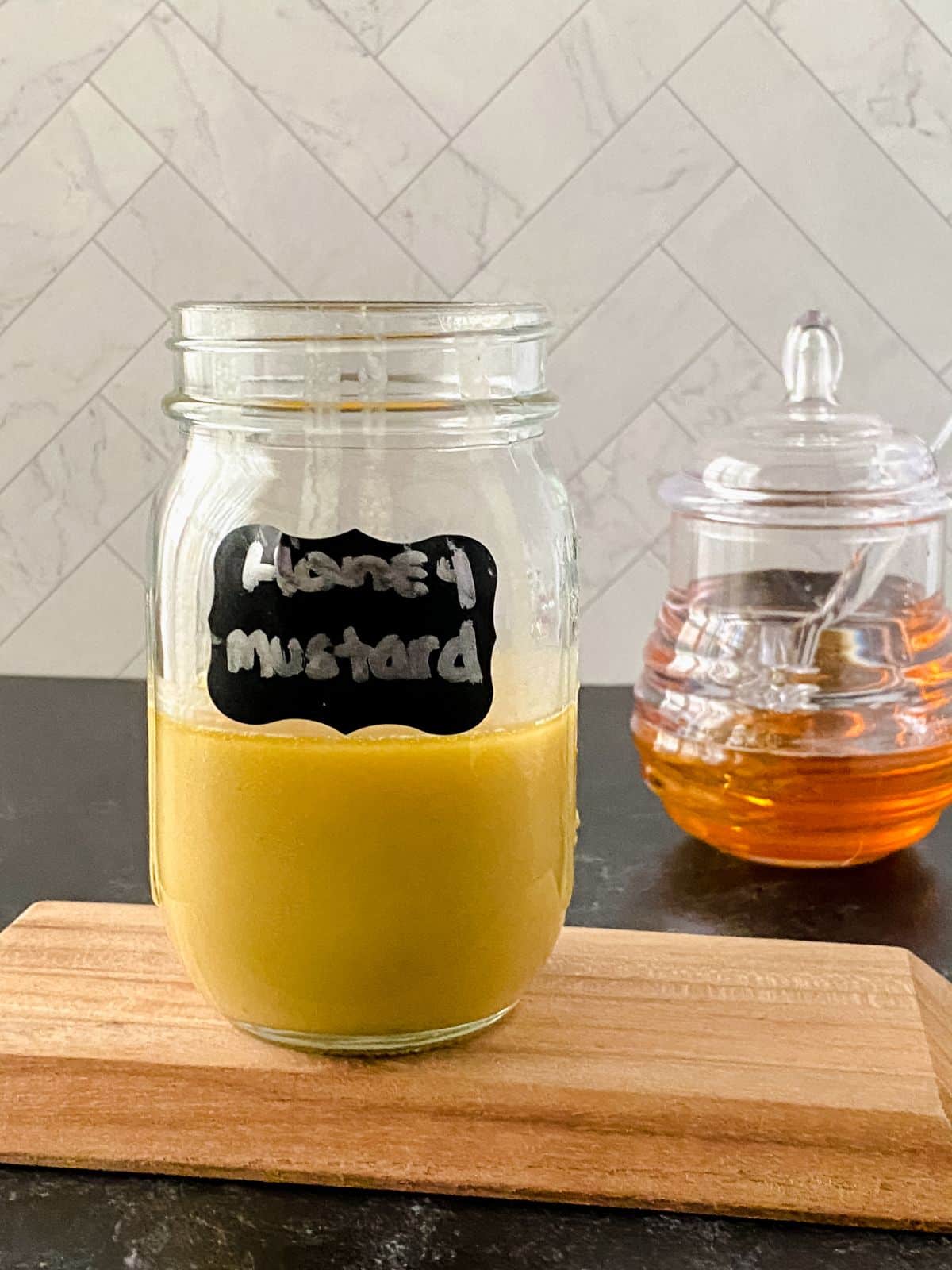 mason jar of honey mustard on cutting board