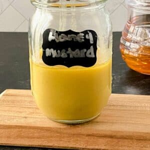 mason jar of honey mustard on cutting board
