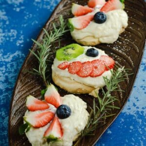 kiwi and strawberry on pavlova cake on blue plate