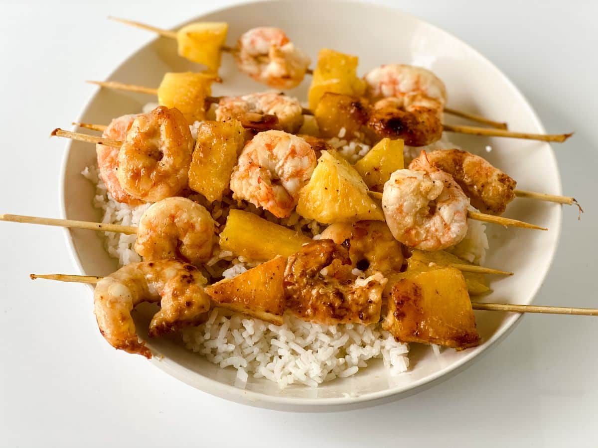 white plate with shrimp kabobs and rice