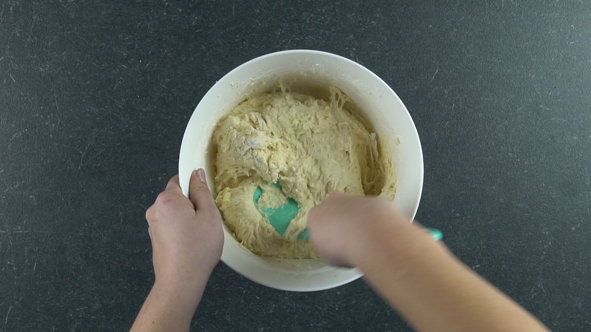 blue spoon mixing potato bread dough