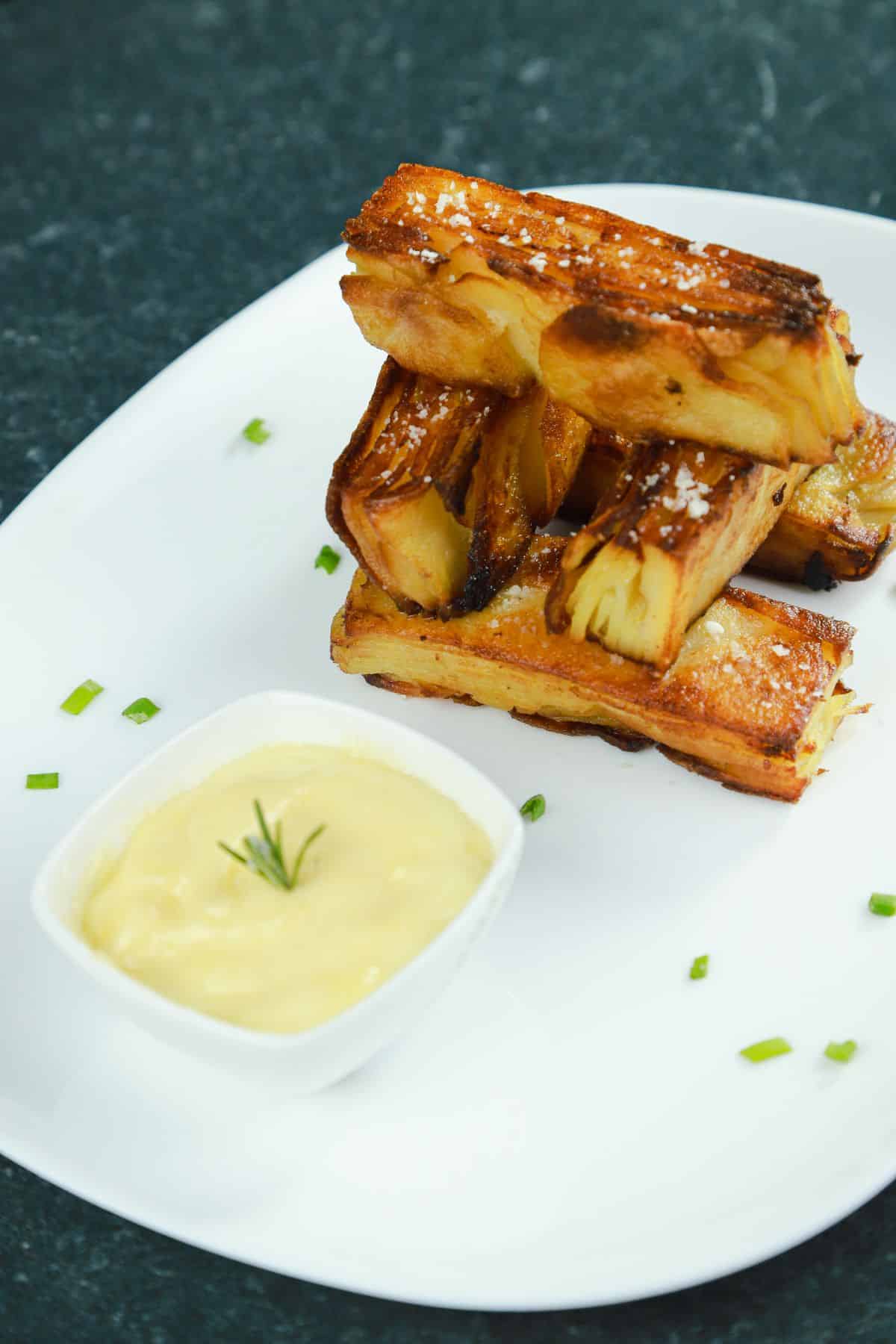 roasted garlic potato terrine stacked on white plate