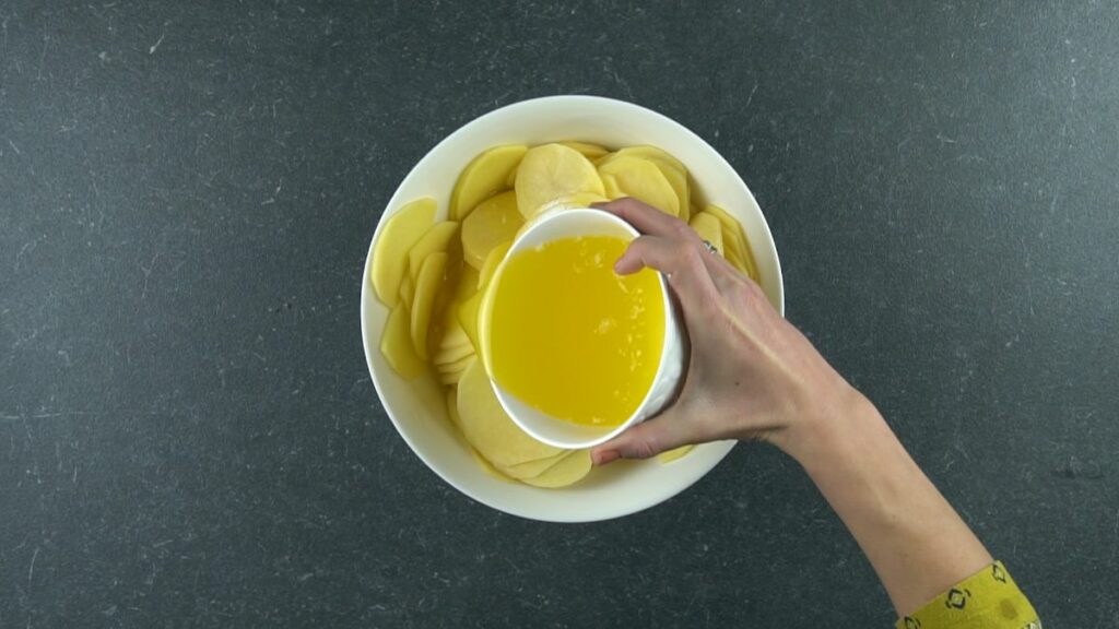 melted butter being poured over potatoes