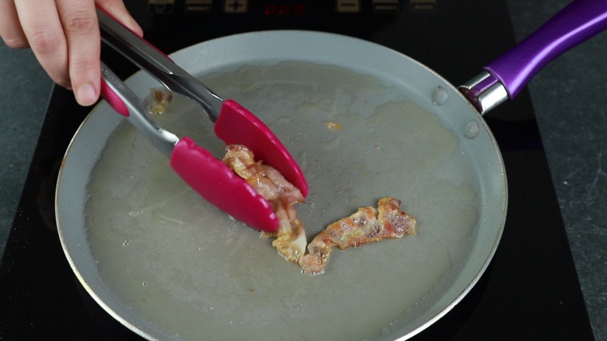 bacon being turned by pink tongs