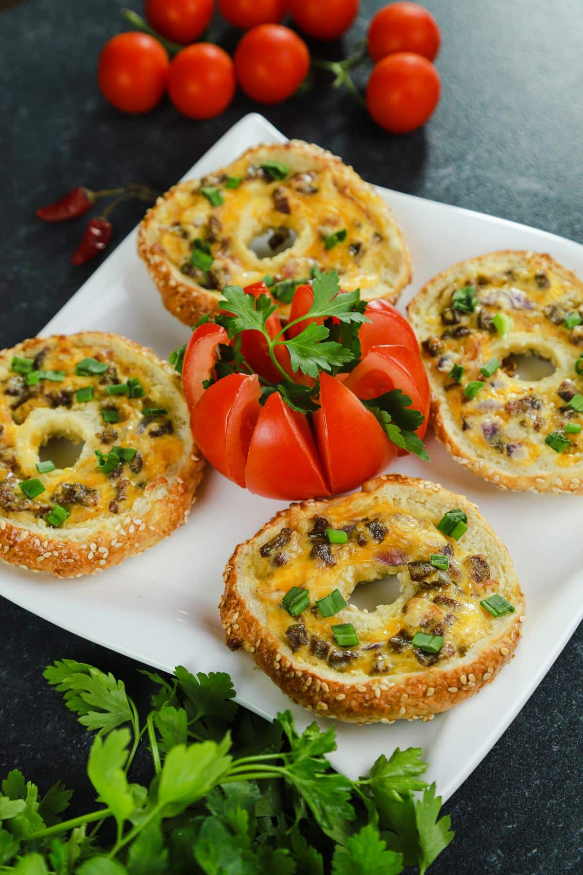 quiche stuffed bagels on white plate with fresh herbs