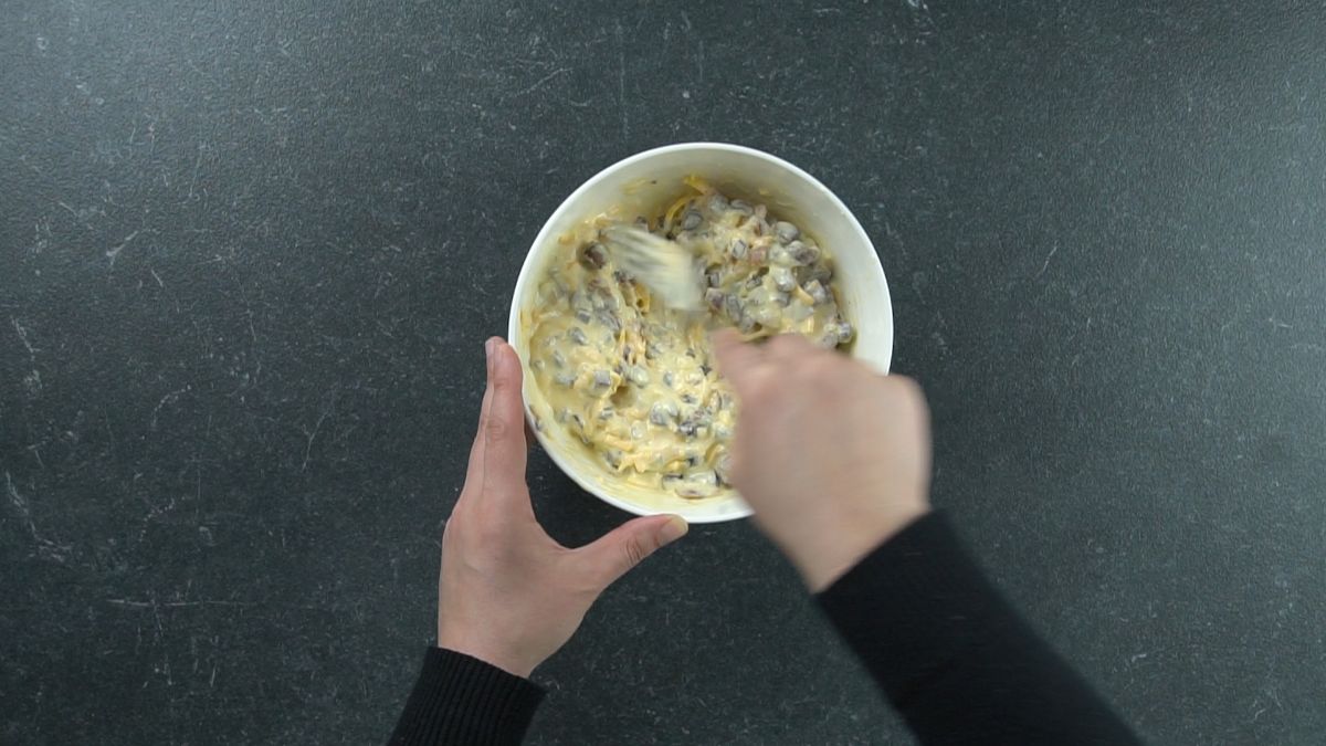 eggs and cheese being stirred in white bowl