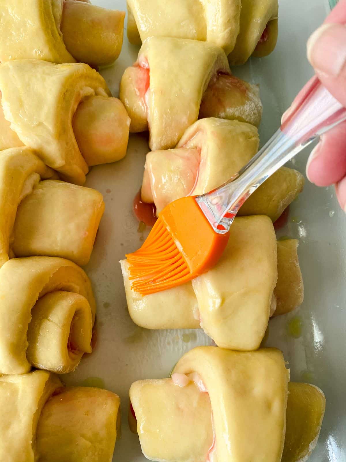 pastry brush on top of stuffed crescent rolls