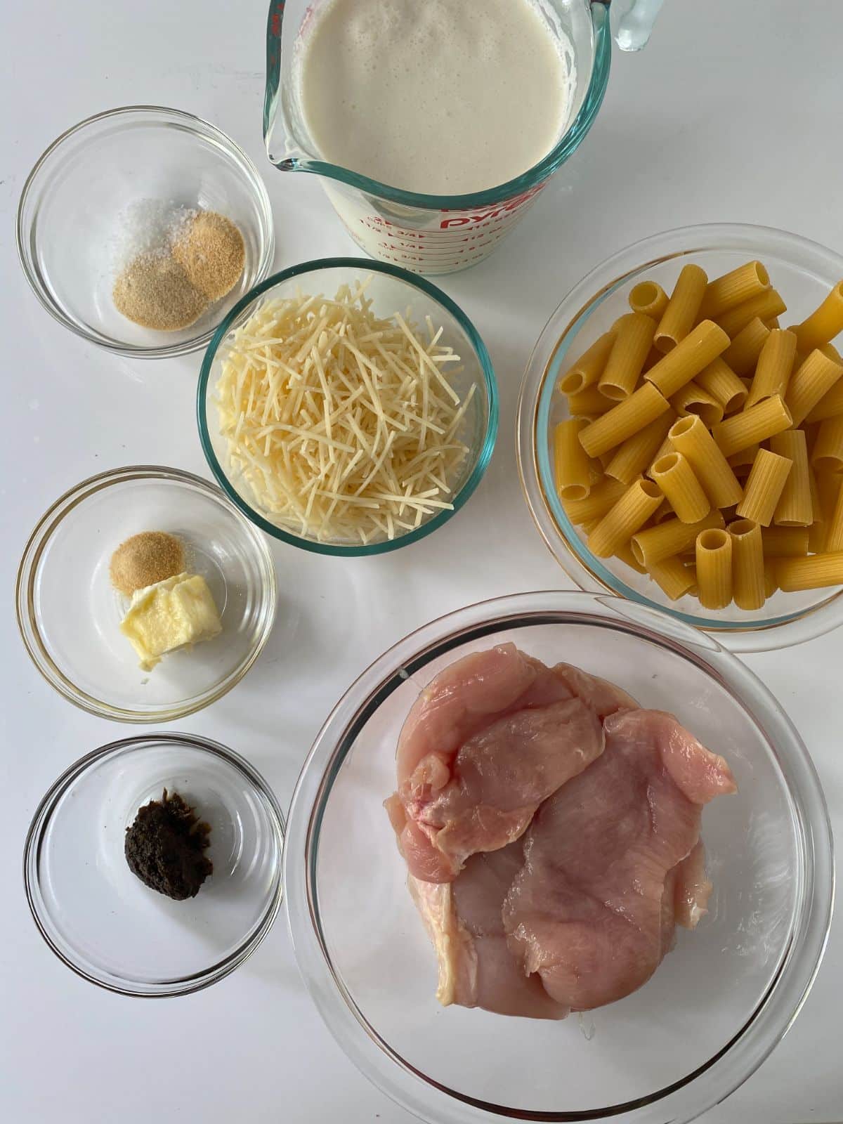 ingredients for rasta pasta in glass bowls on white table
