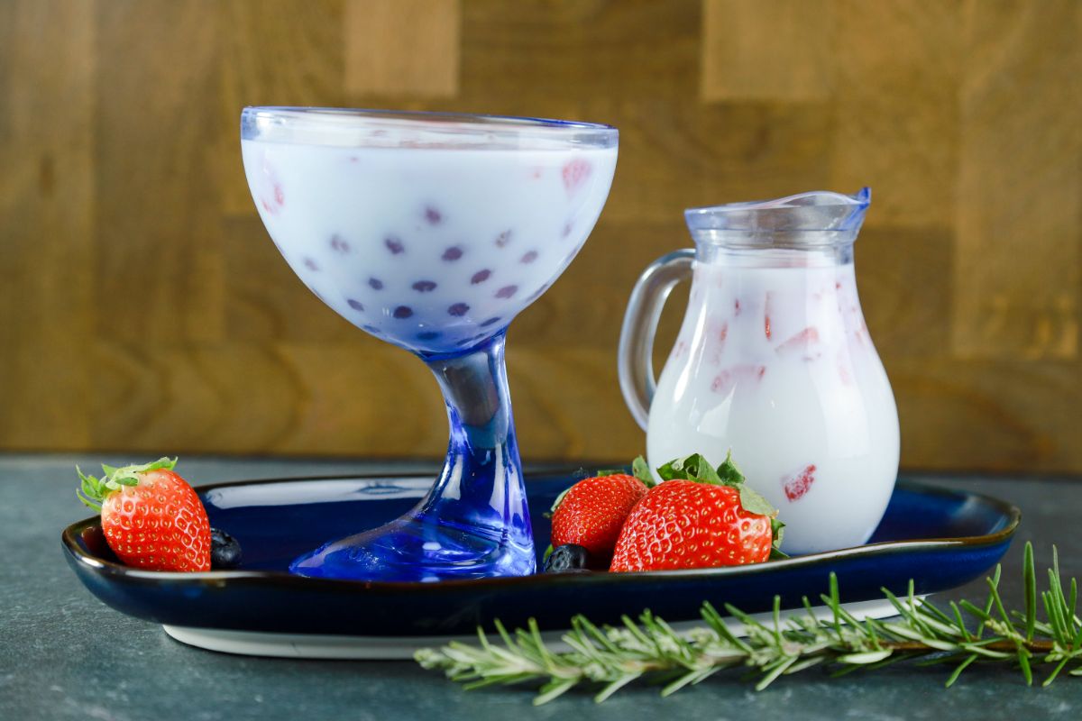 strawberry pieces in blue glass of boba milk