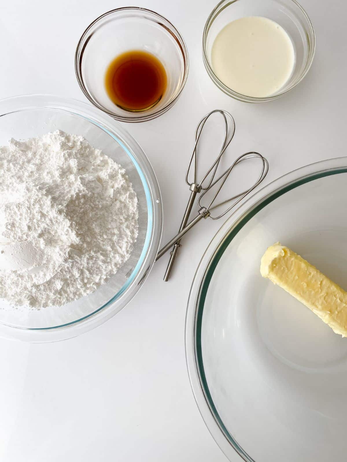 glass bowls of butter and powdered sugar on white table