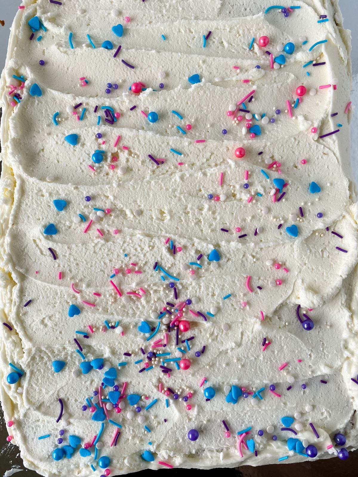 sheet cake topped with white icing and sprinkles