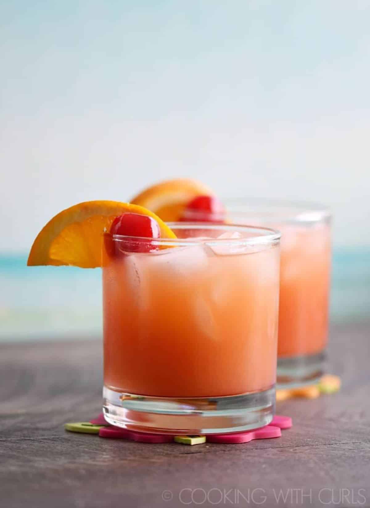 Two glasses of Caribbean Rum Punch cocktail with slices of lemon.