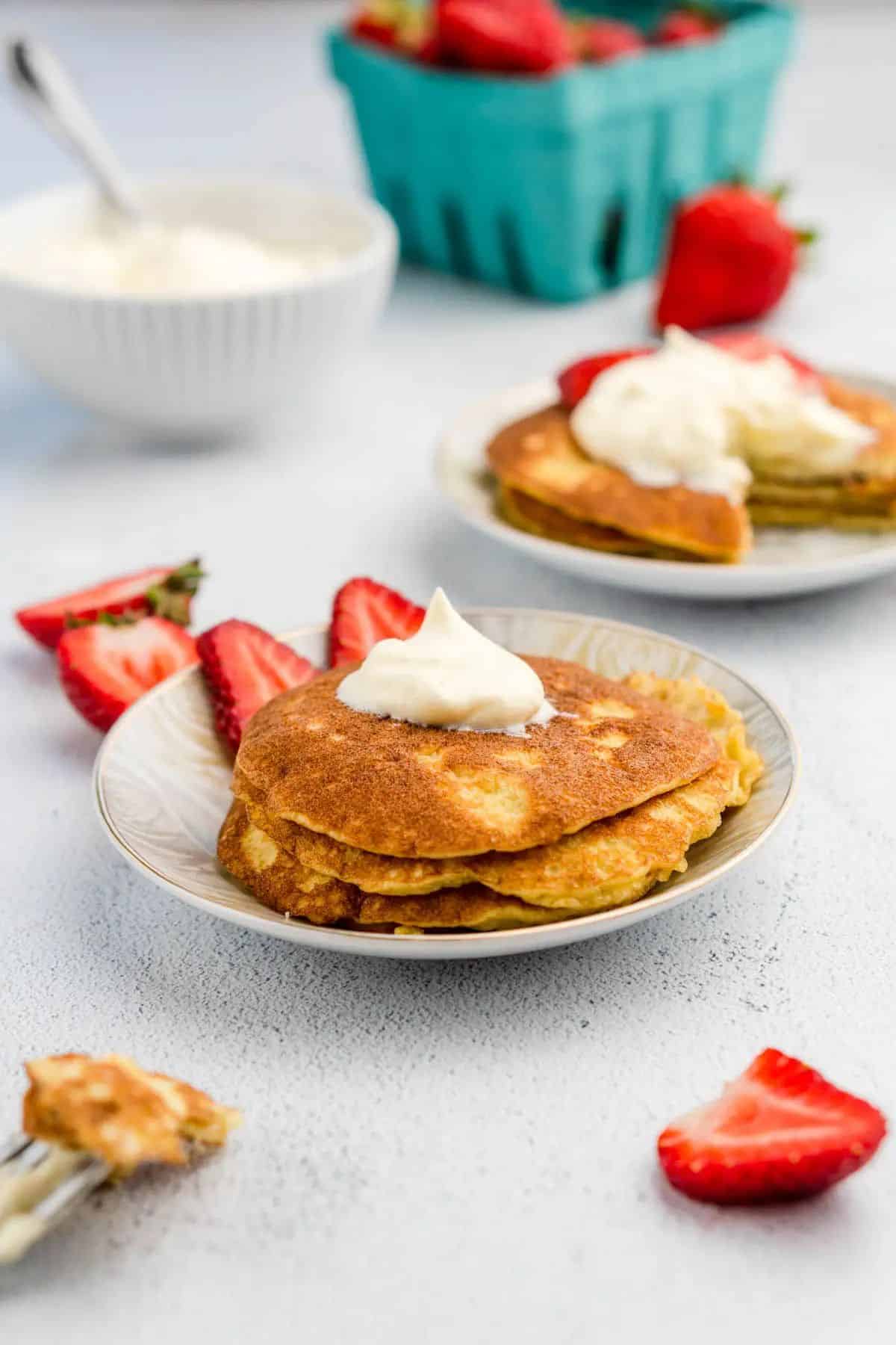 Keto Almond Flour Pancakes without Cream Cheese on small plates with sliced strawberries.