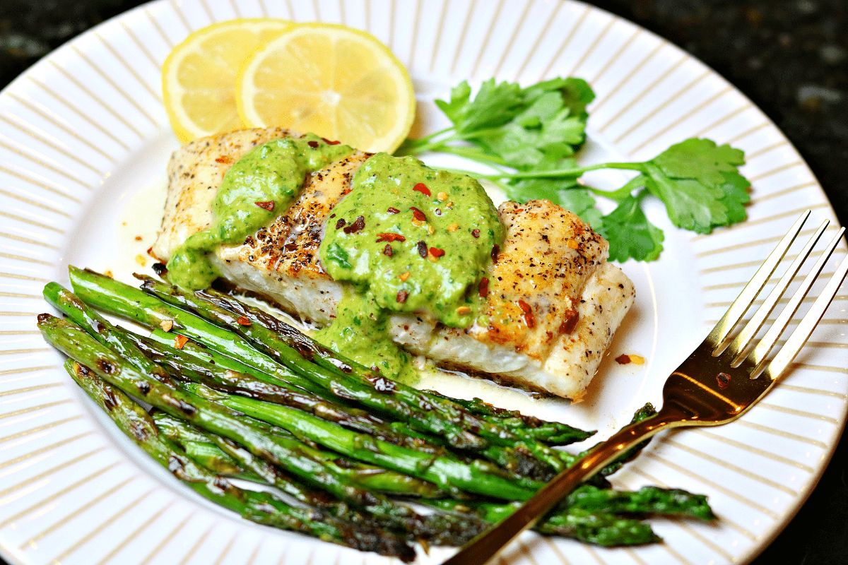 Easy Pan-Seared Halibut on a white plate with a fork.