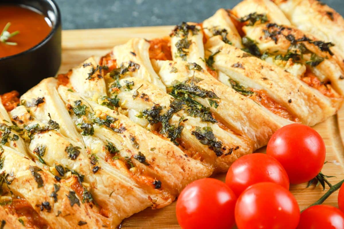 puff pastry stuffed with chicken and sauce on cutting board