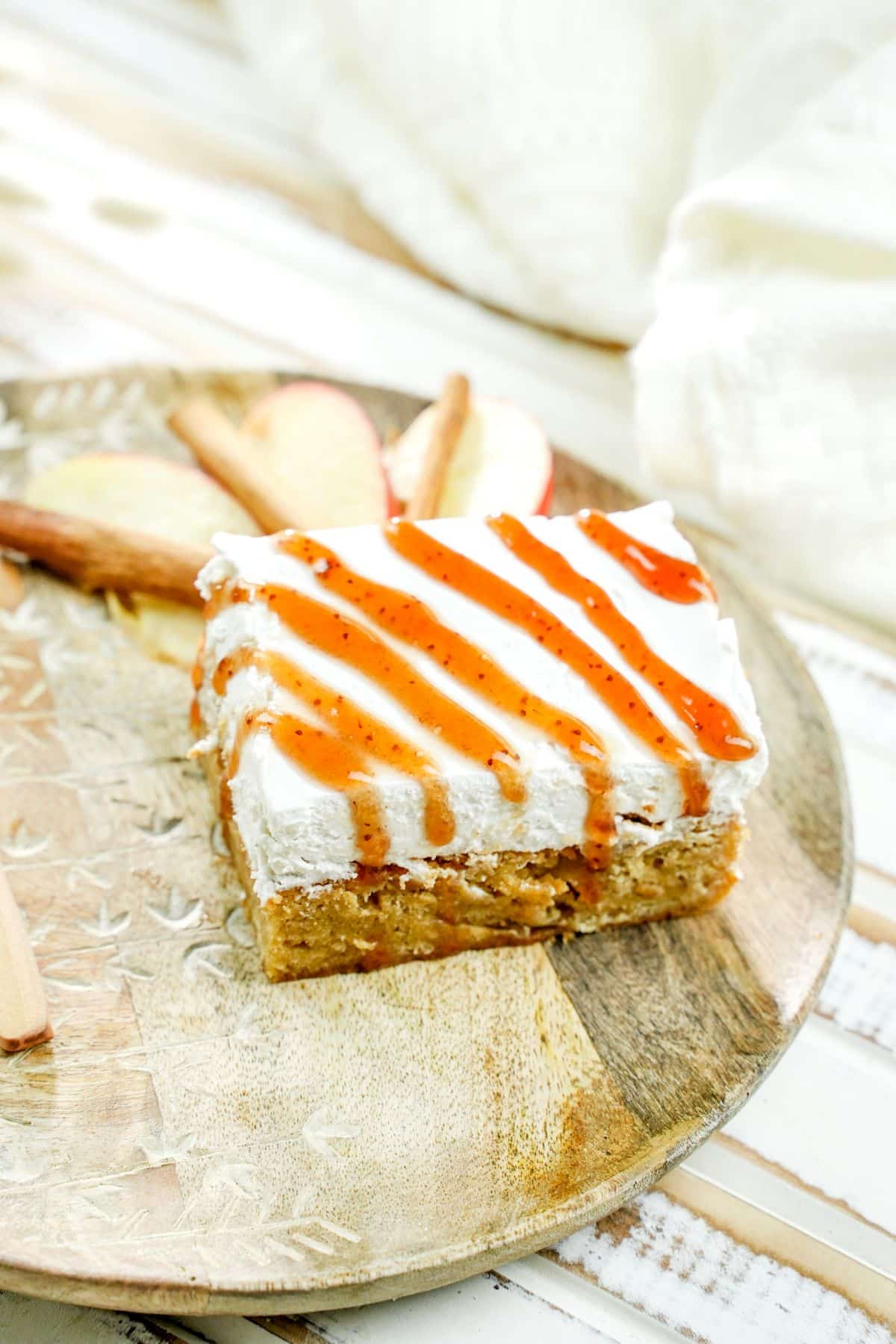 apple cheesecake blondie drizzled with caramel on brown plate