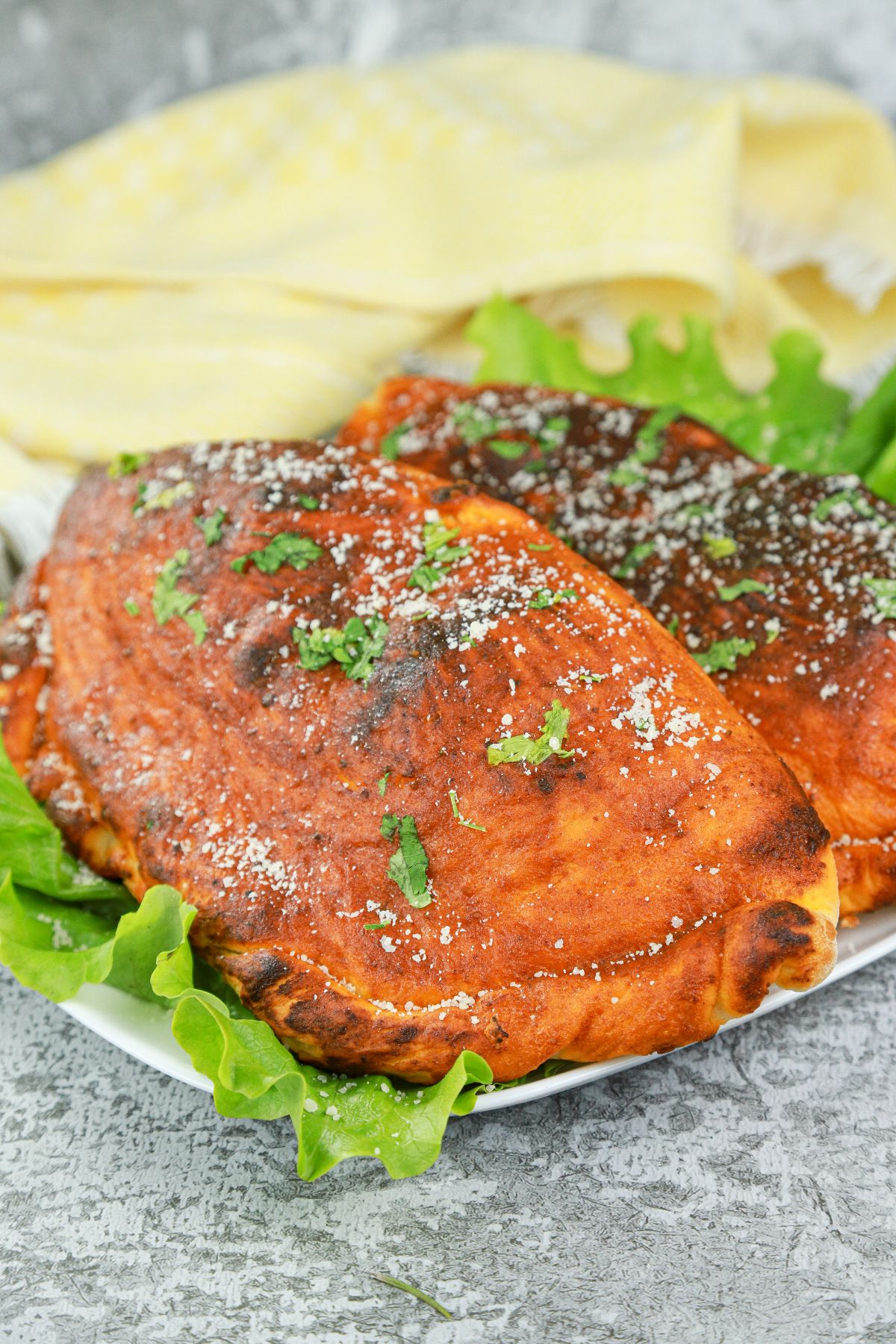 butter chicken calzone on lettuce leaves on plate on granite counter