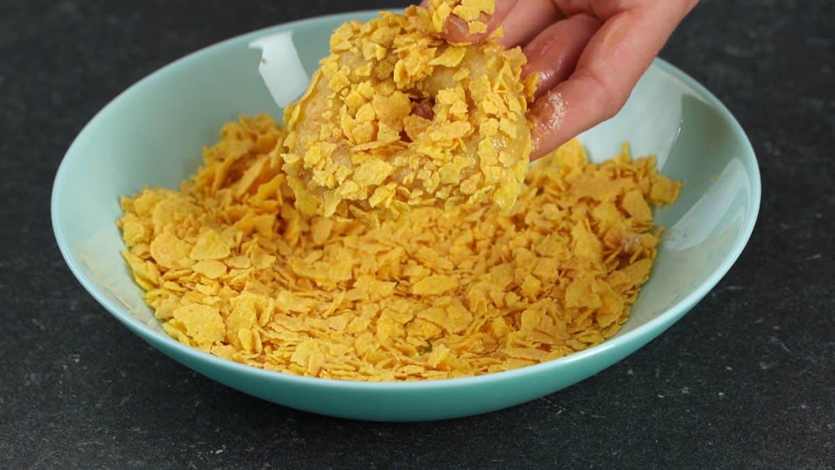 chicken ring being coated in cornflakes