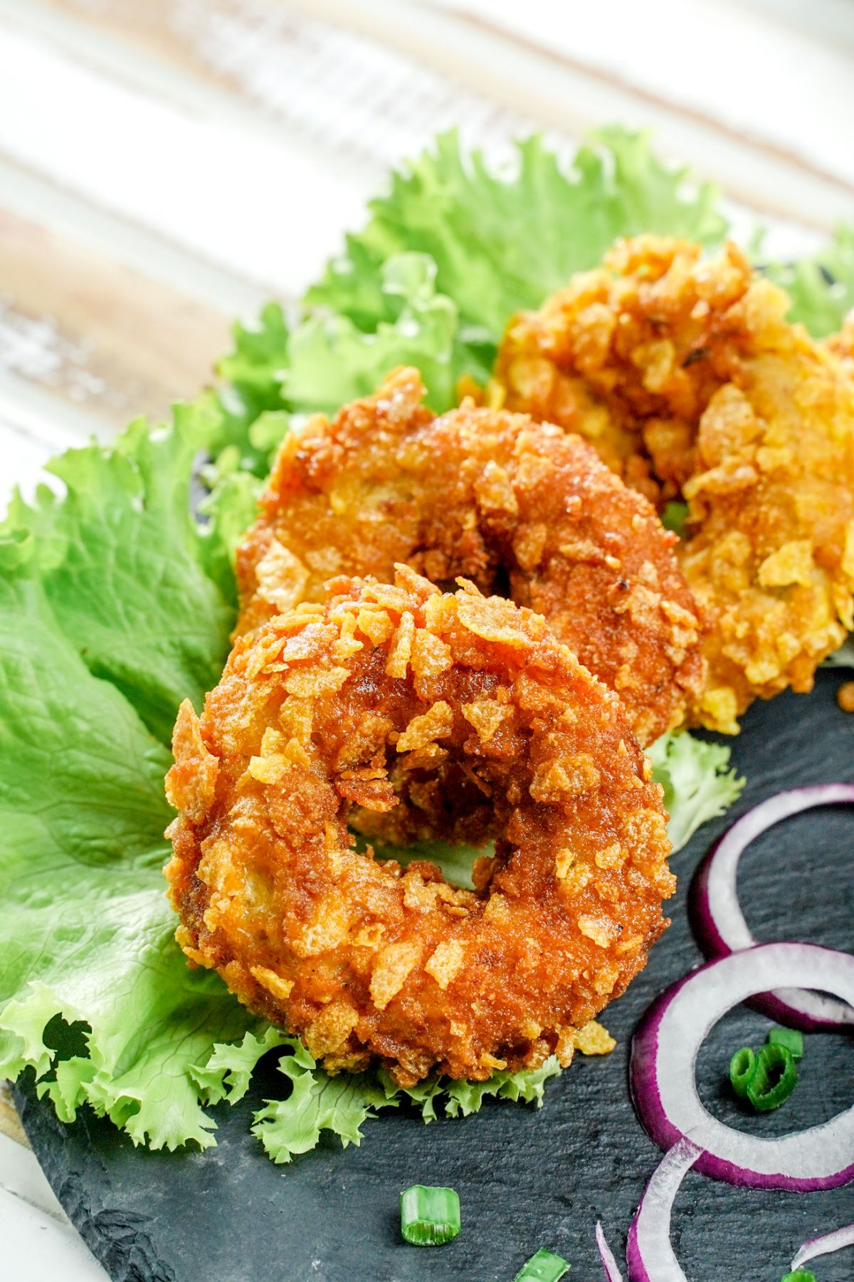 crispy chicken rings on plate with sliced red onion