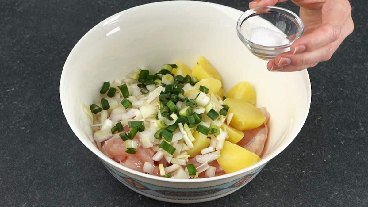 raw chicken in bowl with onions and potatoes