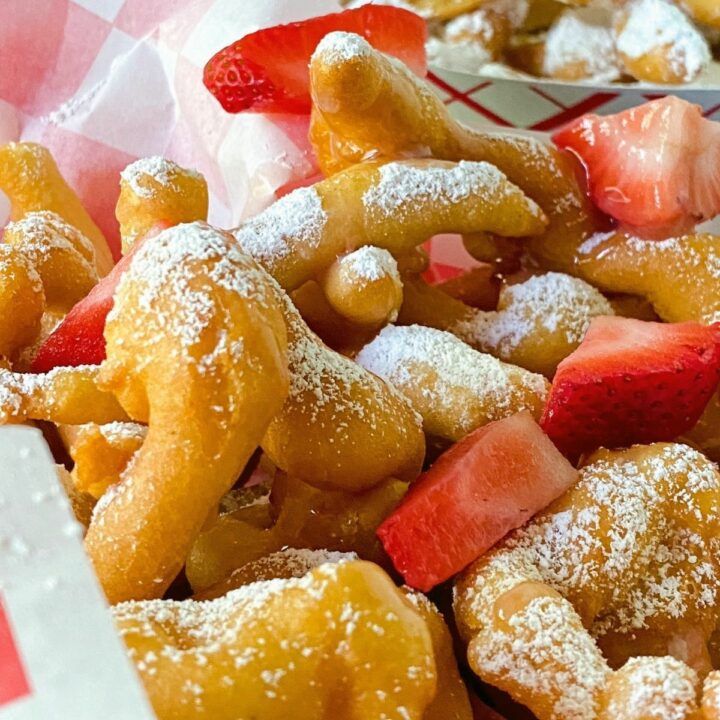 red and white basket of funnel cake fries on black table