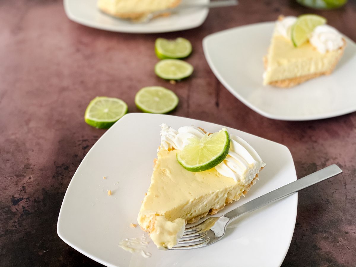 slice of key lime pie on white plate with fork