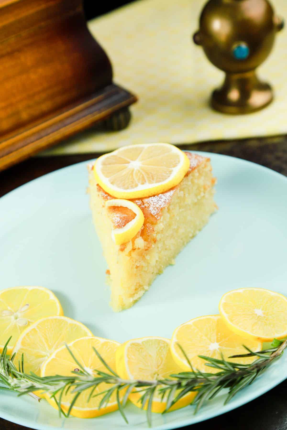 slice of cake on blue plate with lemon slizces