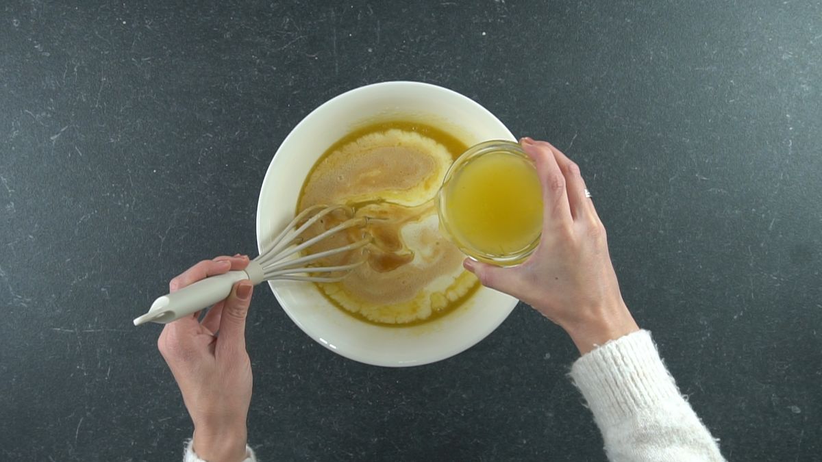 lemon juice being added to large white bowl of batter