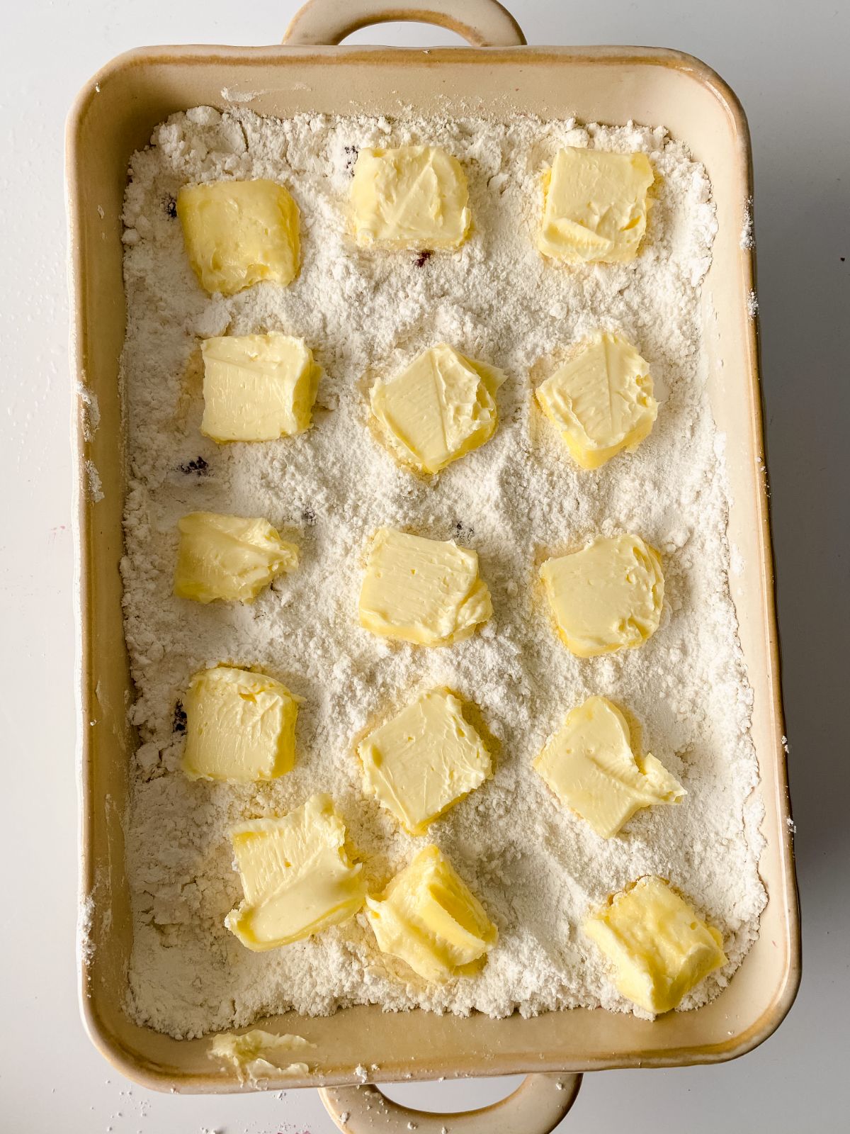baking dish topped with cake mix and tabs of butter