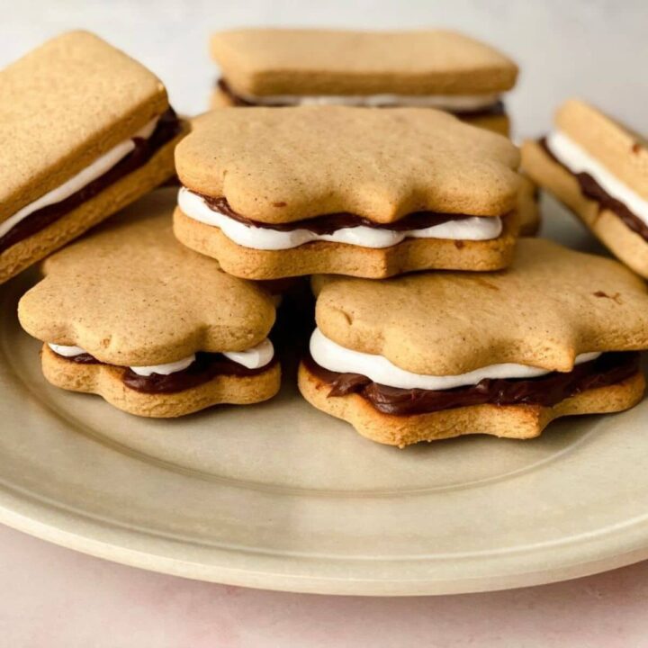 stack of smores cookies on brown plate on table with white background