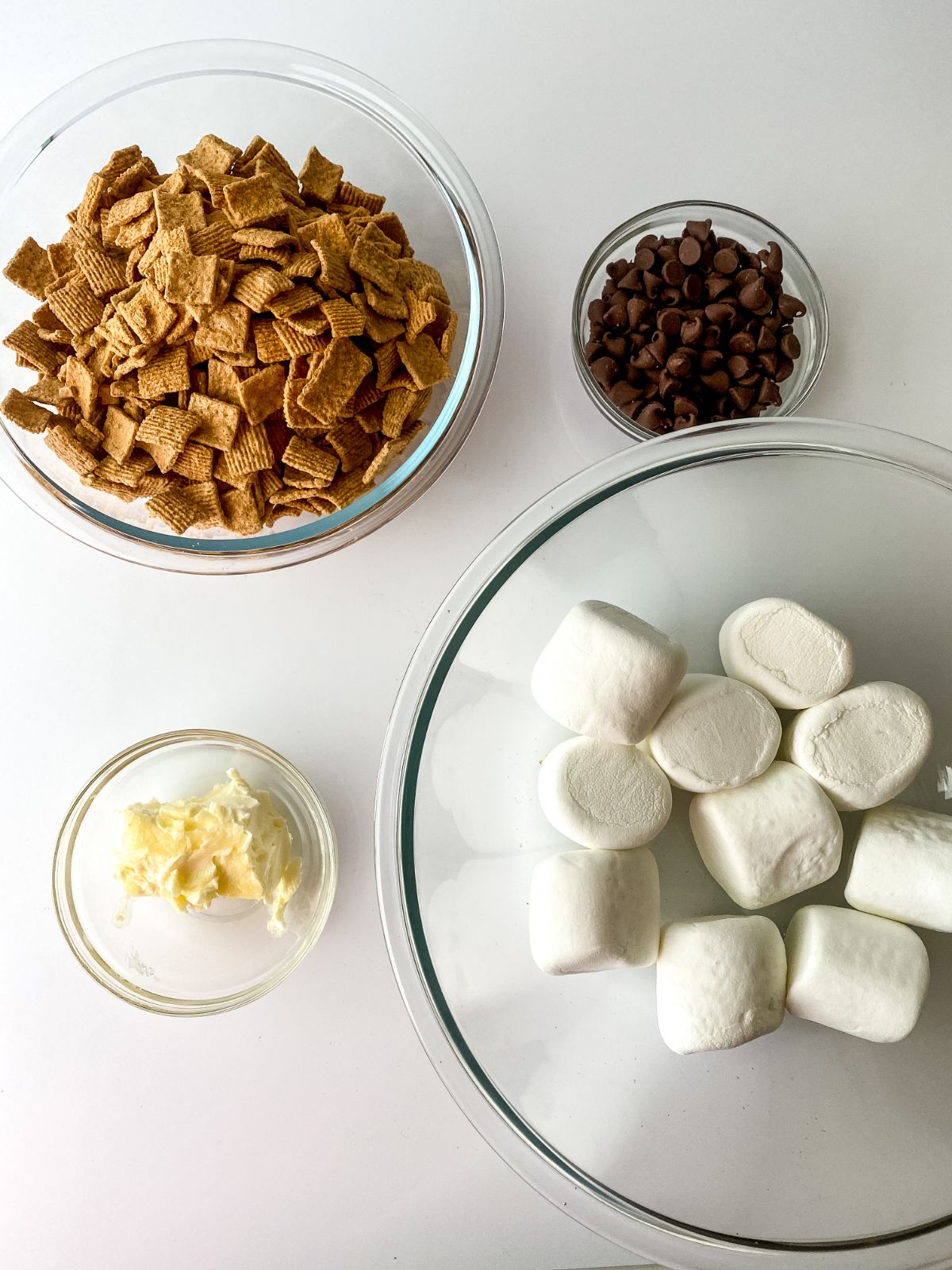 glass bowls of marshmallows and cereal on white counter