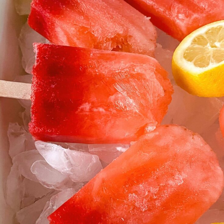 lemon slices on block of ice by strawberry lemonade popsicles