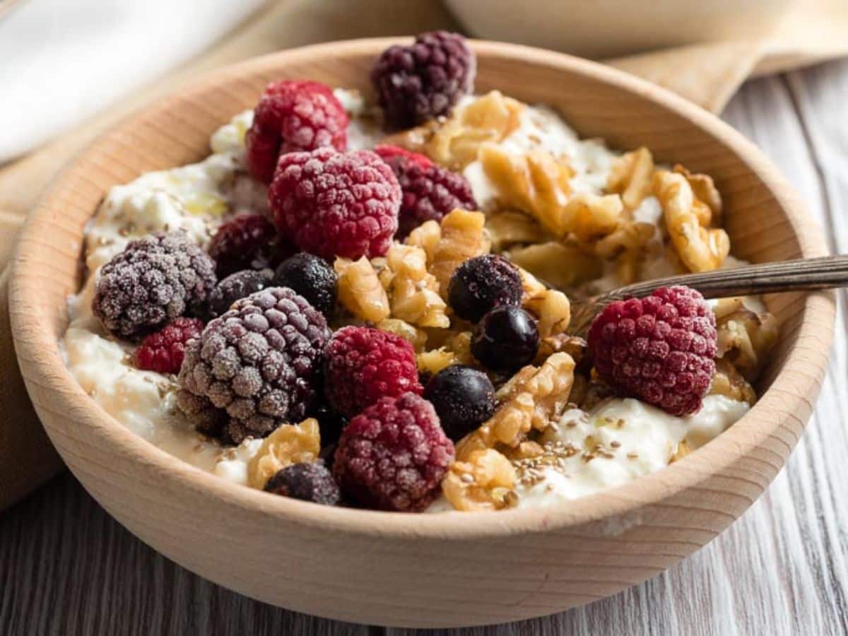 Cottage Cheese Breakfast in a wooden bowl with a spoon.
